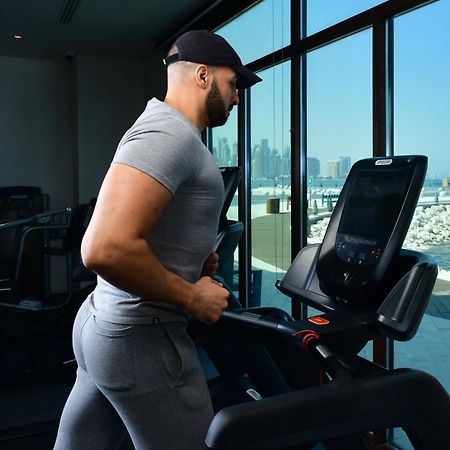 Mina Hotel And Residences By The Torch Doha Kültér fotó A man exercising on a treadmill